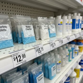 Hovuz kimyası üçün kiçik paketlər qiymət etiketləri ilə rəfdə düzülüb